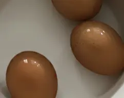 Step <p>Sacarlo del cestillo y colocarlos en un bol con agua fría. </p><p>Para usar estos huevos deben estar a temperatura ambiente o fríos, si se usa en el momento de retirarlos del agua caliente, la clara estará muy líquida y no monta bien.</p> illustration