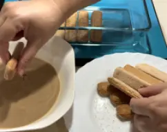Step <p><span style="font-weight: normal;">Bañe una a una las galletas de soletilla, debe ser rápido y no deben quedar muy empapadas. Colóquelas una a una en la base de la fuente hasta que quede bien cubierto.</span></p> illustration