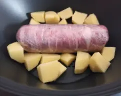 Step <p>Estirar en una mesa el filete de pechuga de pollo, salpimentar, poner en el centro del filete las lonchas de jamón, los orejones, las pasas y cubrir con las lonchas de queso. Enrollar.</p><p>En un trozo de papel film poner las lonchas de beicon en vertical una junto a otra, situar encima el rulo, enrollar haciendo presión como si fuera un brazo de gitano y dar un par de vueltas con el papel. Cortar y cogiendo de los extremos girar sobre la mesa para compactar, remetiendo los extremos. </p><p>Colocar en el Varoma y reservar. </p> illustration